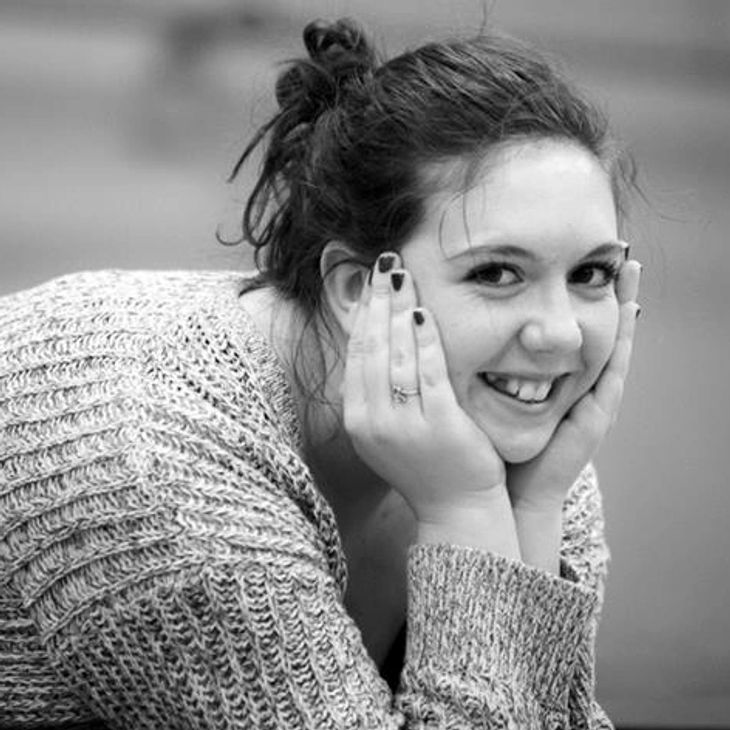 A young woman smiling while stretching in class