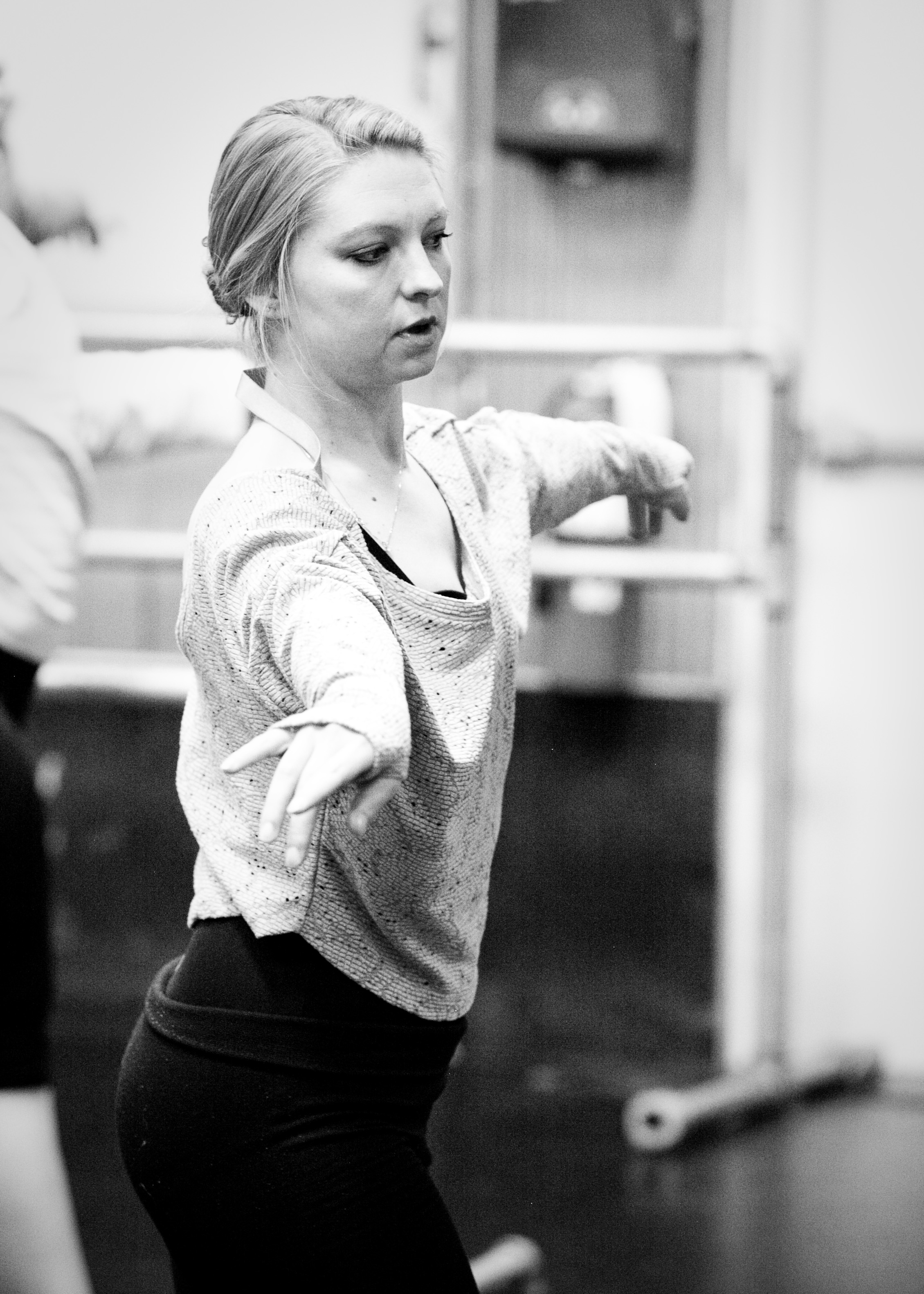 young woman leading her jazz class through dance