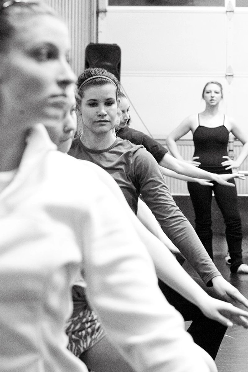 A teacher teaching her upper-level adult students at the ballet barre