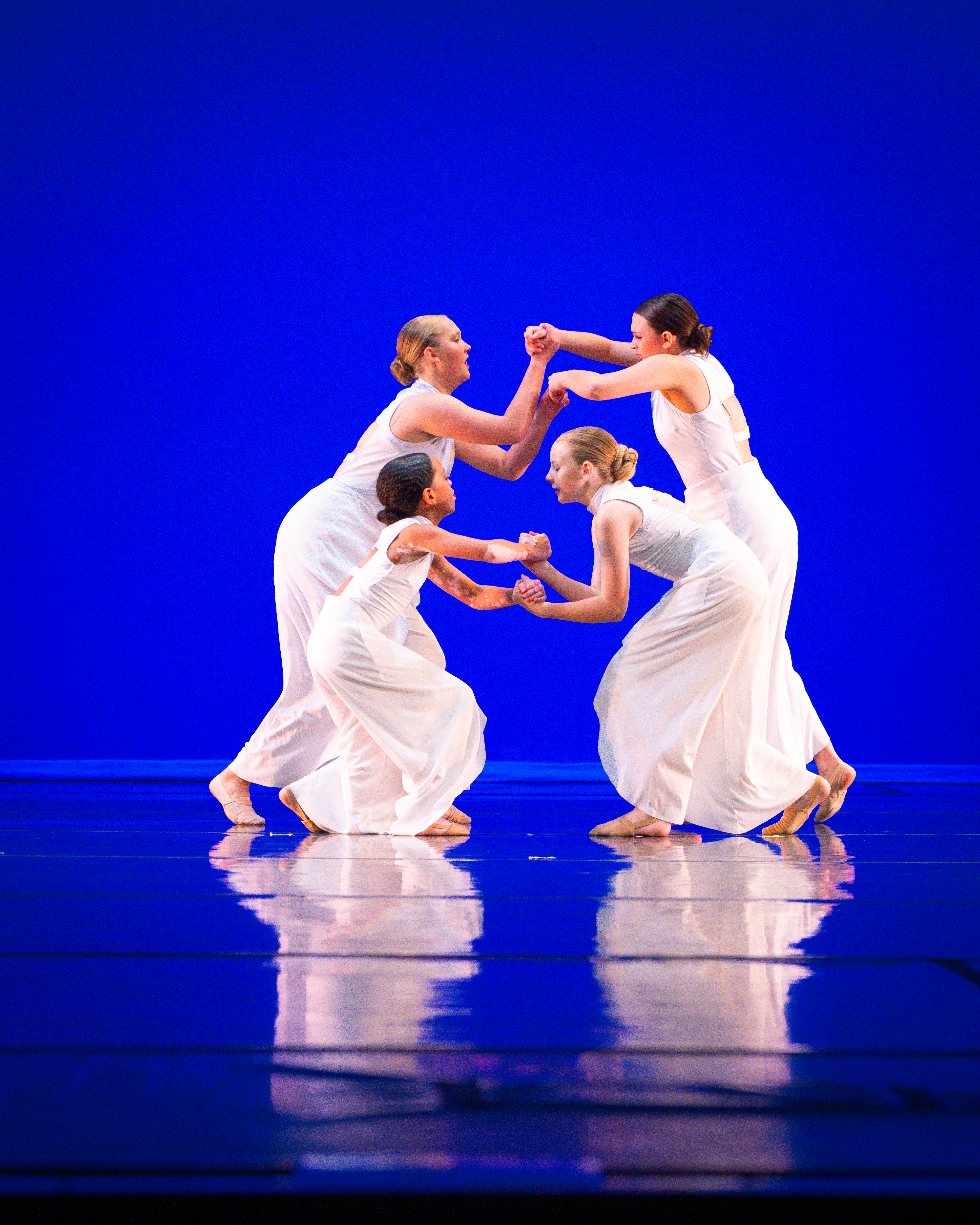 Youth dancers shining together on stage at the annual studio recital