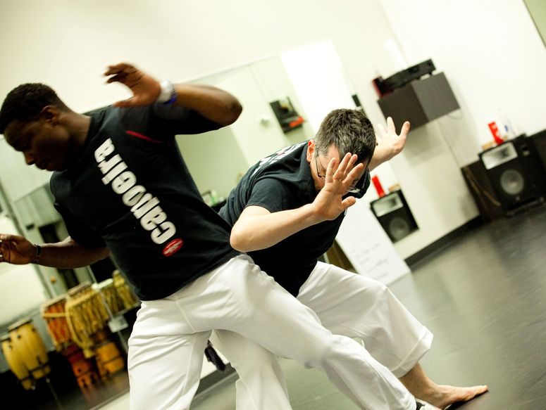 Two people increasing trust in one another through Capoeira dodges. 