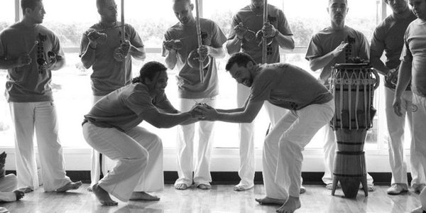 Two students working together before playing a capoeira game in the roda. 