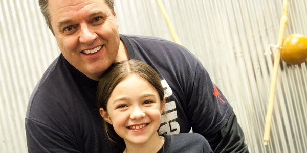 A father-daughter duo sharing a compassionate moment after class. 
