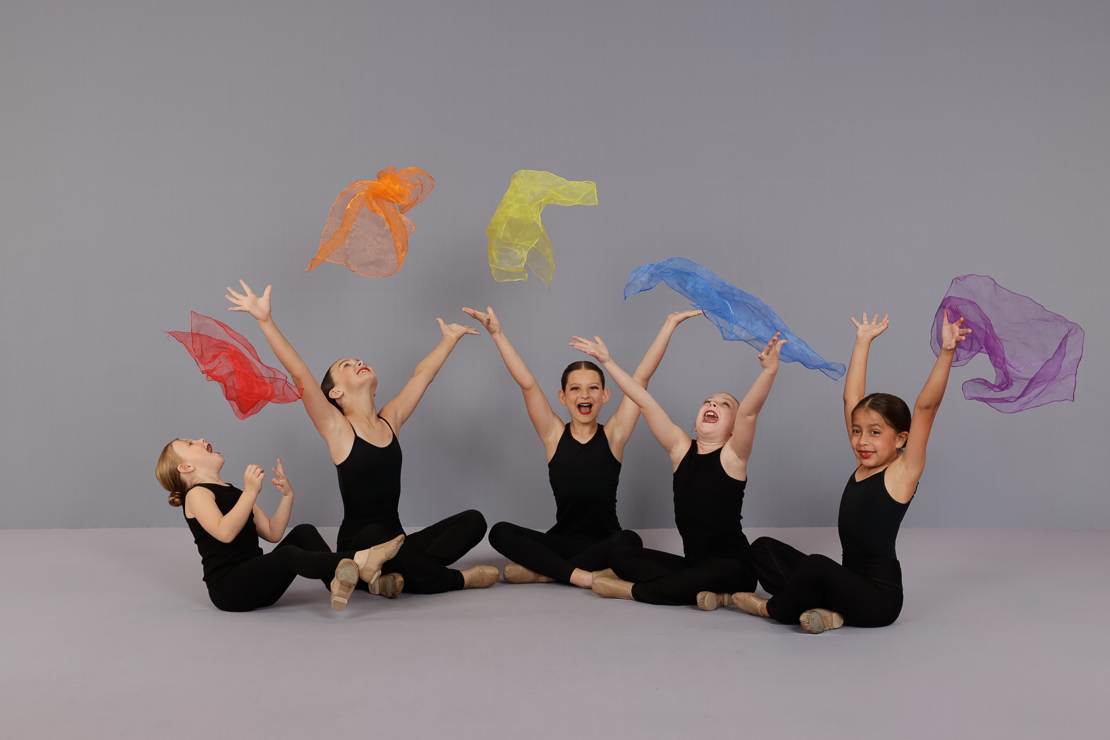 Preschoolers engaged in movement with colorful scarfs